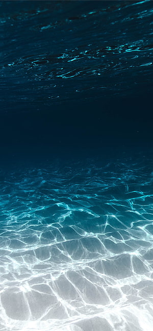 Underwater View of Sunlit Sand and Turquoise Ocean Water HD phone wallpaper