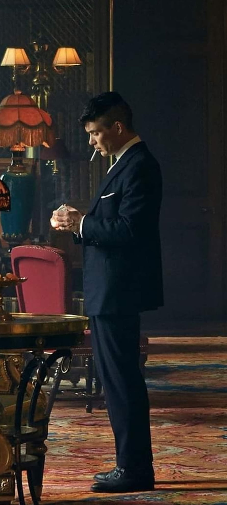 Tommy Shelby in a dark suit smoking a cigarette in a vintage room HD phone wallpaper