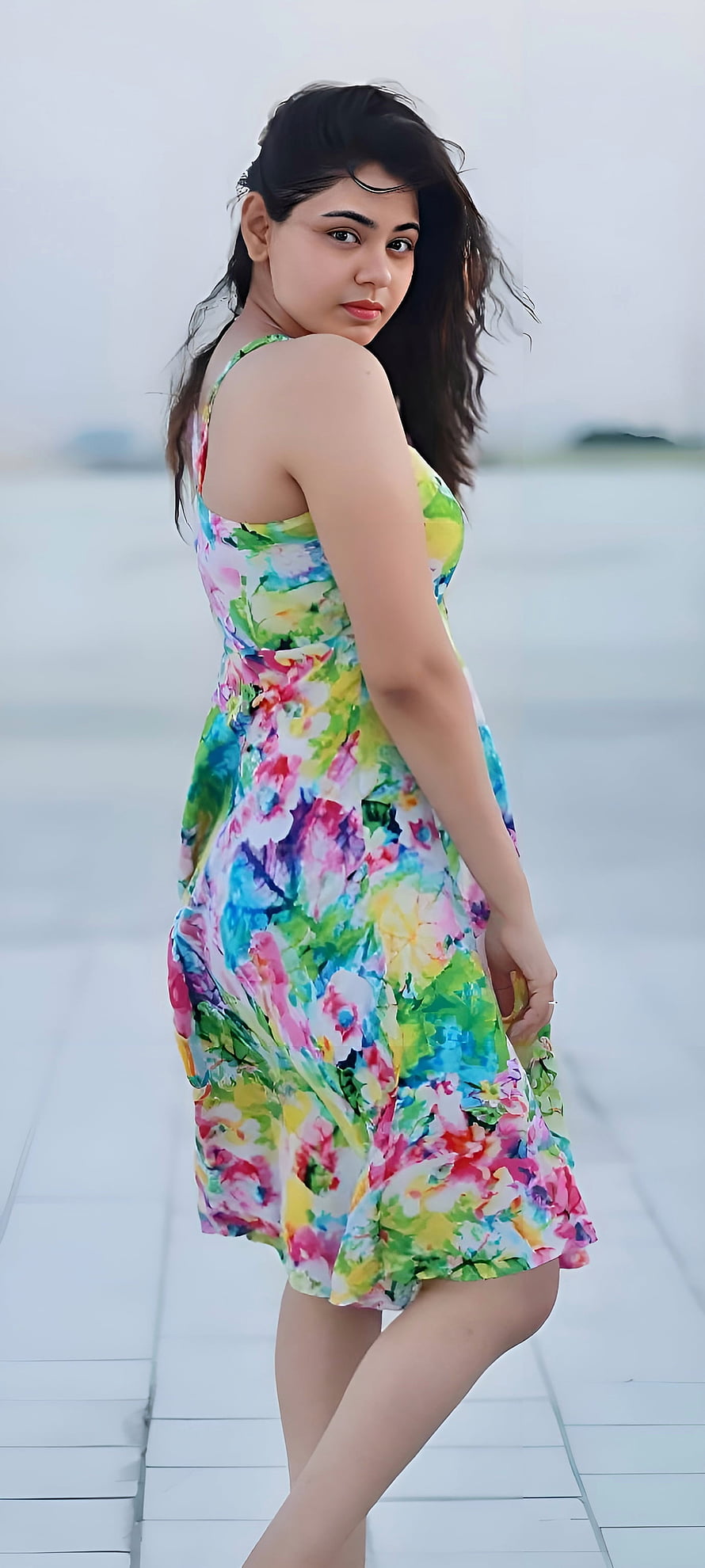 Young woman in a vibrant floral summer dress standing on a white tiled walkway, Beautiful girl, dress, hair, indian HD phone wallpaper