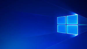 Glowing Windows 10 Logo on Deep Blue Gradient Background HD wallpaper