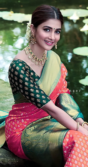 Pooja Hegde in a vibrant multi-colored silk saree with traditional gold jewelry by a serene pond HD phone wallpaper