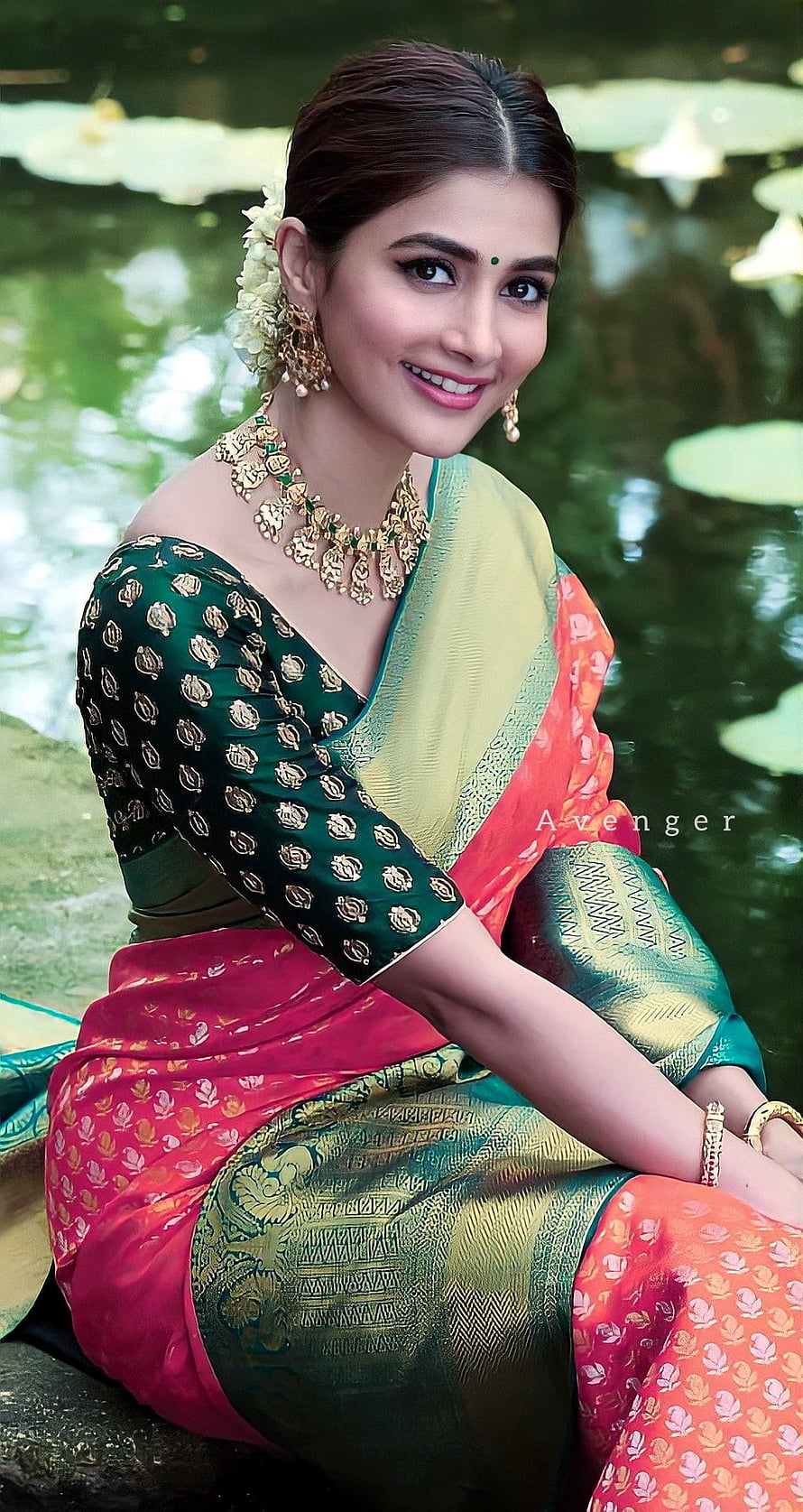Pooja Hegde in a vibrant multi-colored silk saree with traditional gold jewelry by a serene pond HD phone wallpaper