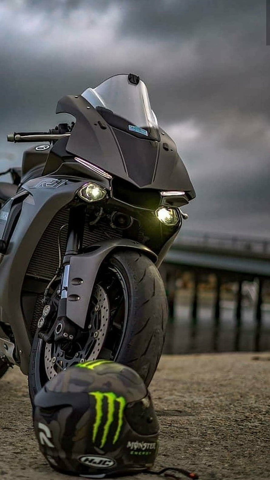 Matte Black Yamaha R1 Motorcycle with Monster Energy Helmet on Pier HD phone wallpaper
