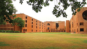 Modern Red Brick University Campus Architecture with Green Lawn and Trees HD wallpaper