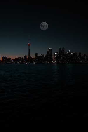 Toronto skyline at night with the full moon rising over Lake Ontario and the CN Tower HD phone wallpaper