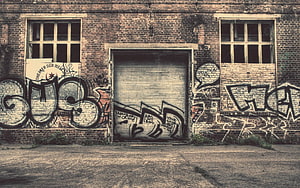 Urban Decay: Weathered Brick Wall Covered in Street Art and Graffiti Tags HD wallpaper