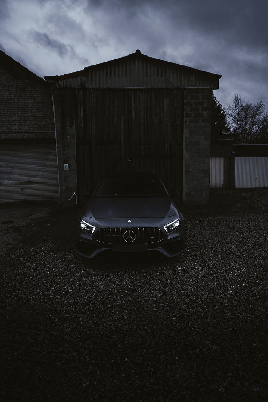 Dark Matte Mercedes-AMG A45 S Front View in Moody Industrial Setting HD phone wallpaper