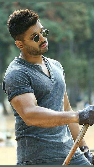Allu Arjun in Grey Henley Shirt and Round Sunglasses Holding a Wooden Pole HD phone wallpaper