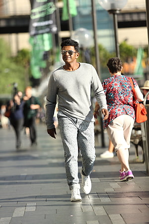 Puneeth Rajkumar in Grey Sweatshirt and Patterned Trousers Walking on a City Street HD phone wallpaper