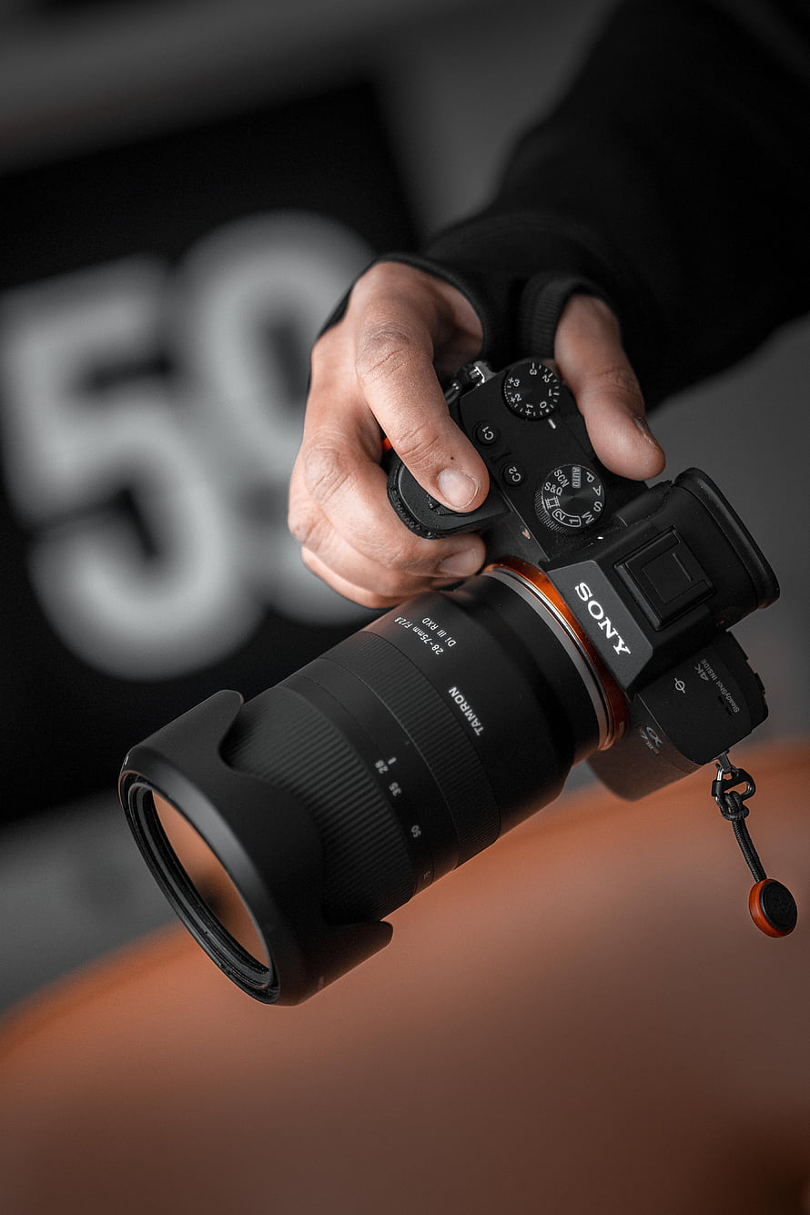 Sony A7 Mirrorless Camera with Tamron 28-75mm Lens in Hand HD phone wallpaper
