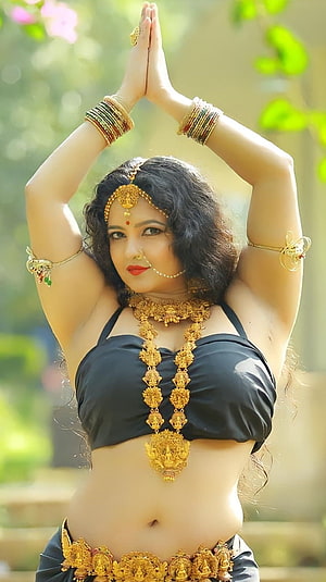 Shubha Punja in Traditional Gold Jewelry and Black Attire with Hands in Prayer Pose HD phone wallpaper