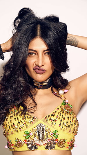 Shruti Hassan in ornate yellow embellished crop top with playful expression and voluminous dark hair HD phone wallpaper