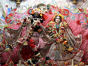 Radha Rani and Krishna Deities in Ornate Temple Attire with Floral Garlands HD wallpaper