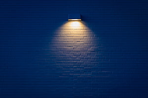 Warm Spotlight Illuminating Dark Blue Brick Wall Texture Background HD wallpaper