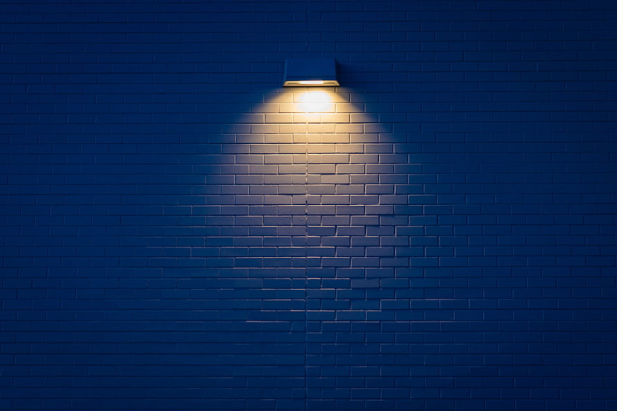 Warm Spotlight Illuminating Dark Blue Brick Wall Texture Background HD wallpaper