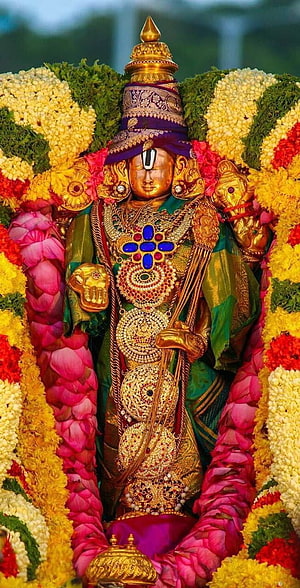 Tirumala Utsava Murthy adorned in vibrant floral garlands and ornate gold jewelry HD phone wallpaper