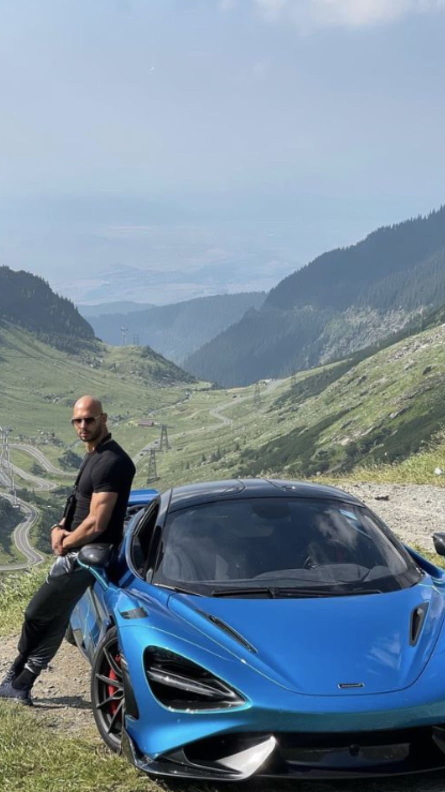 Man Leaning on Blue McLaren 720S Super Car in Mountain Landscape, Andrew Tate, mclaren, andrewtate HD phone wallpaper