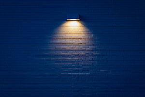 Warm Spotlight Illuminating Dark Blue Brick Wall Texture Background HD wallpaper