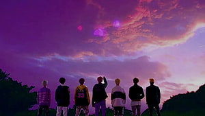 BTS members standing together watching a vibrant purple and pink sunset sky HD wallpaper