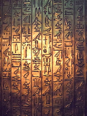 Carved Egyptian Hieroglyphs on Bronze Surface with Golden Illumination HD phone wallpaper