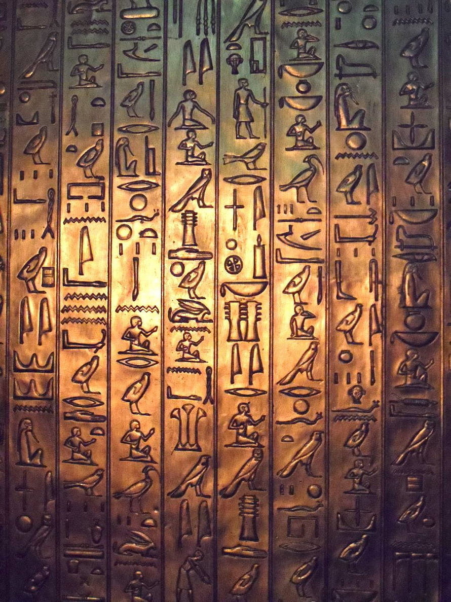 Carved Egyptian Hieroglyphs on Bronze Surface with Golden Illumination HD phone wallpaper