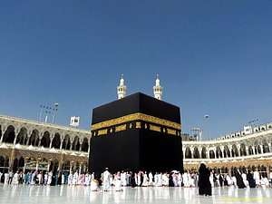 The Kaaba in Mecca with Pilgrims Performing Tawaf Under a Clear Blue Sky HD wallpaper