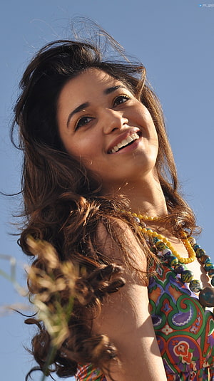 Tamanna Bhatia smiling portrait with flowing hair against a clear blue sky HD phone wallpaper