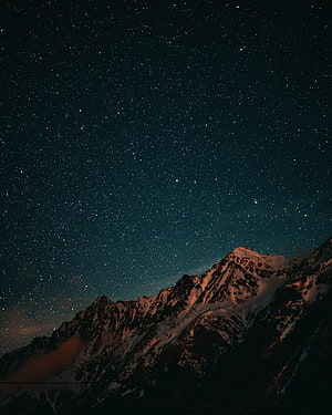 Snow-Capped Alpine Peaks Under a Deep Starry Night Sky HD phone wallpaper