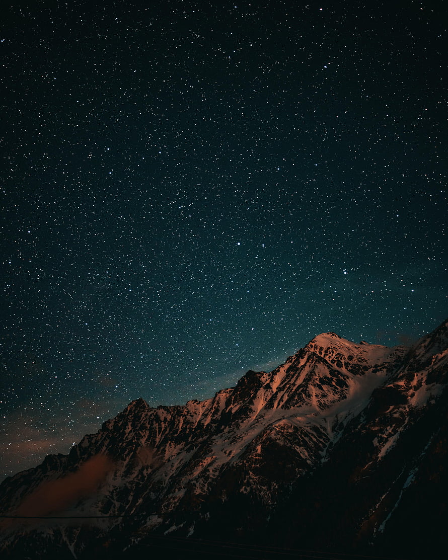 Snow-Capped Alpine Peaks Under a Deep Starry Night Sky HD phone wallpaper