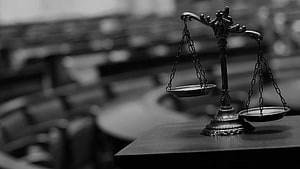 Black and White Photo of Scales of Justice on a Desk in a Courtroom HD wallpaper