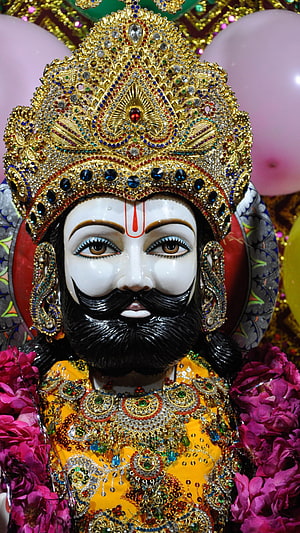 Ornate Idol of Lord Jagannath with Golden Crown and Floral Garlands HD phone wallpaper