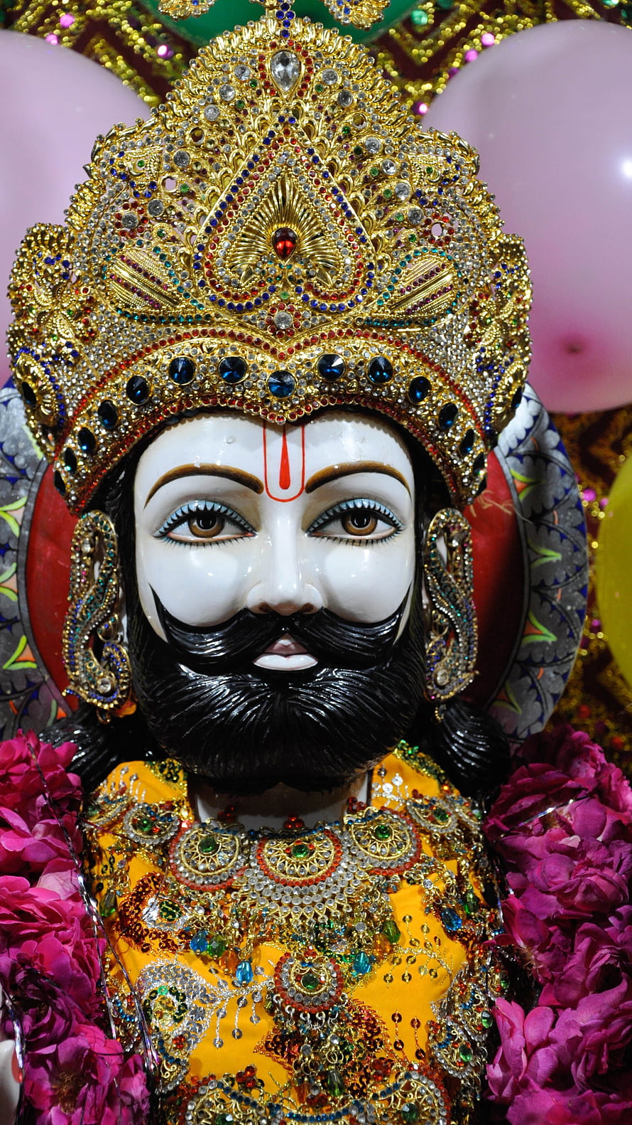 Ornate Idol of Lord Jagannath with Golden Crown and Floral Garlands HD phone wallpaper