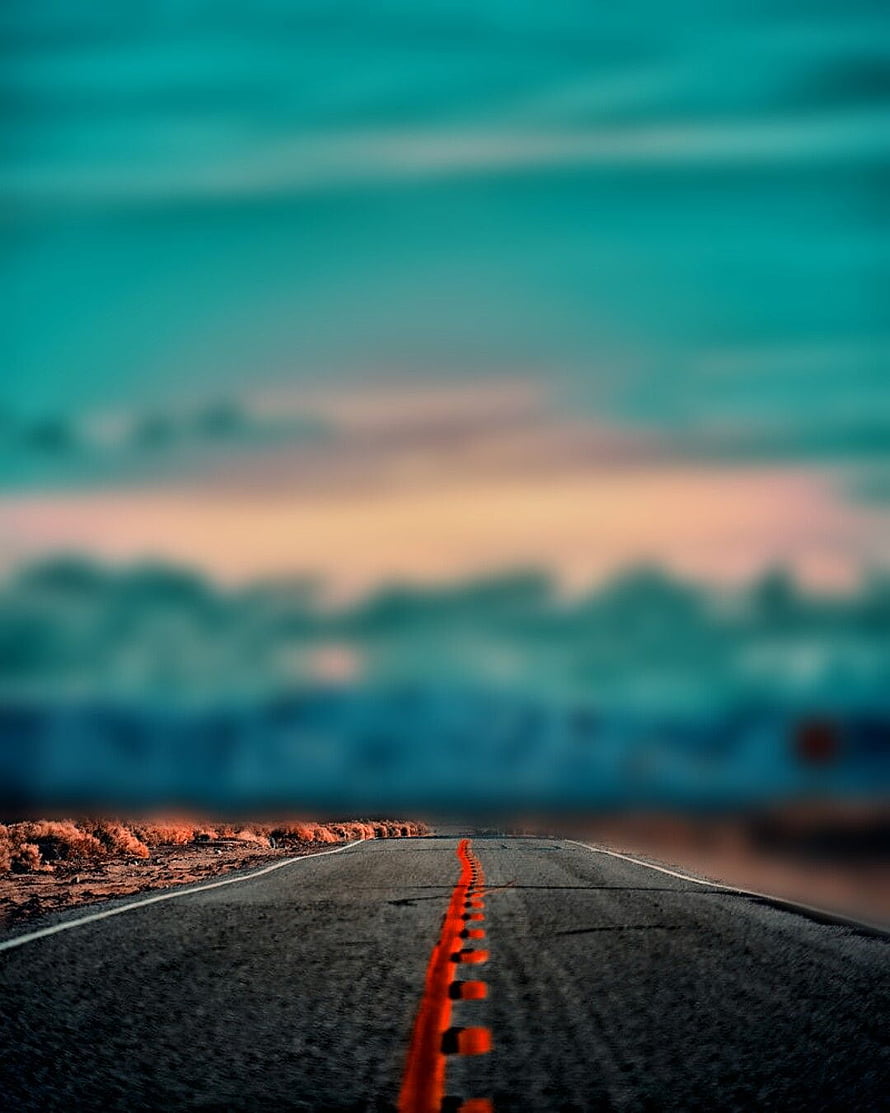 Abstract Blurred Highway Road With Vibrant Orange Center Line And Teal Sky Background HD phone wallpaper