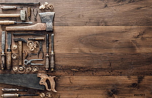 Vintage carpentry tools arranged on rustic wooden workbench surface HD wallpaper