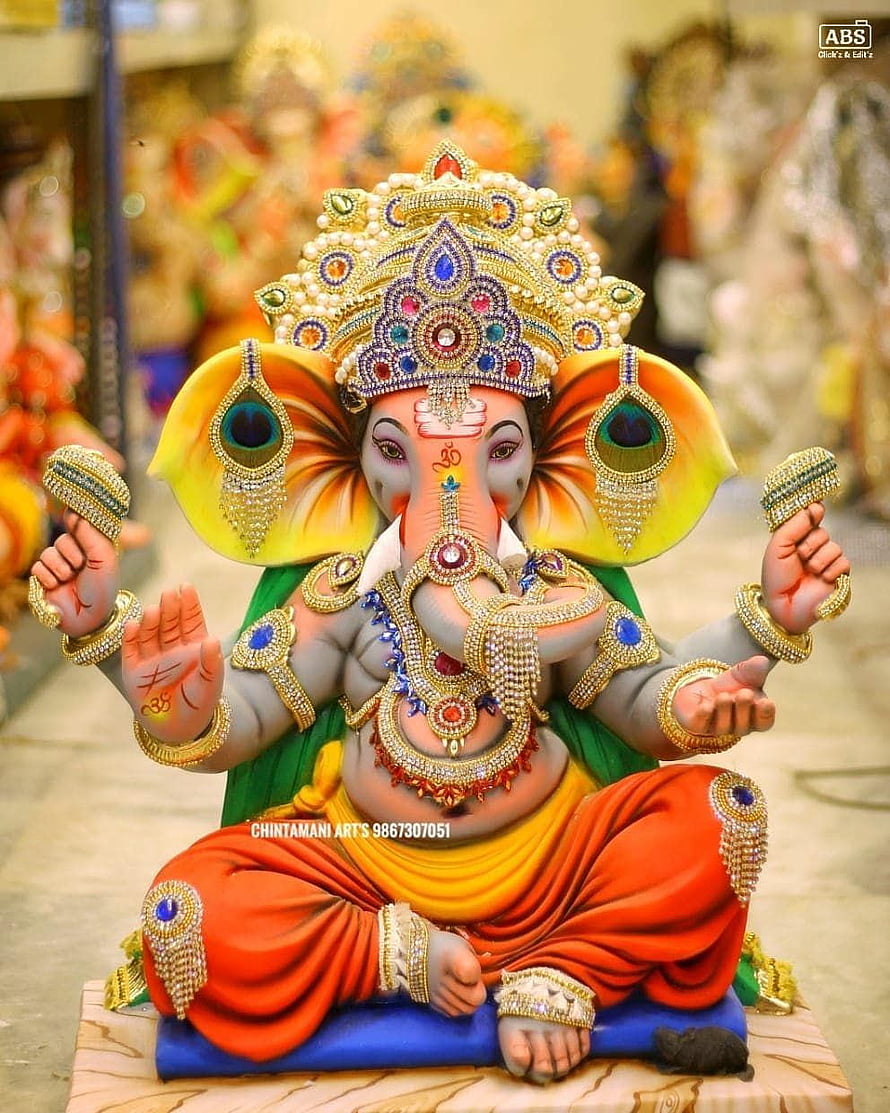 Ornate Ganesha Statue with Jeweled Crown and Peacock Earrings HD phone wallpaper