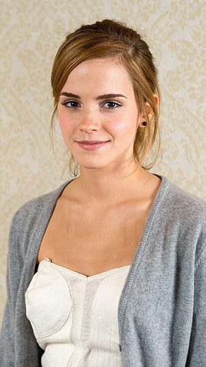 Emma Watson Portrait in Grey Cardigan and White Top Against Patterned Beige Background HD phone wallpaper