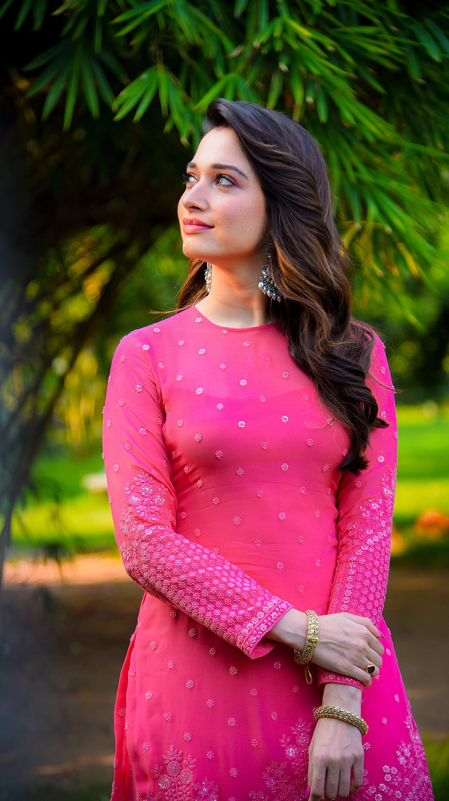 Tamannaah Bhatia in a vibrant pink embroidered kurta with traditional jewelry, posing outdoors amidst lush green foliage, Tamanna Bhatia, multilingual actress, model HD phone wallpaper