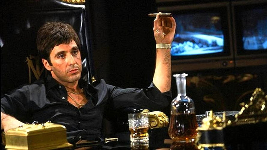 Al Pacino as Tony Montana in Scarface holding a cigar in a dark office HD wallpaper