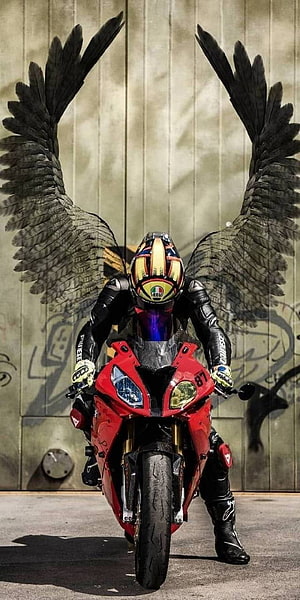 Biker with Black Angel Wings on Red Sport Motorcycle in Urban Setting HD phone wallpaper