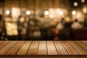 Warm Wooden Table Surface With Blurred Cafe Background And Soft Bokeh Lights HD wallpaper