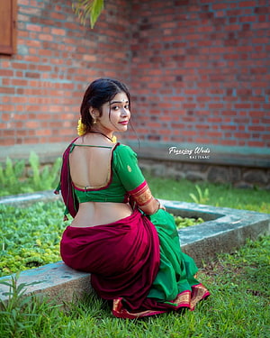Dharsha Gupta in a Green and Maroon Saree Seated on a Garden Bench HD phone wallpaper