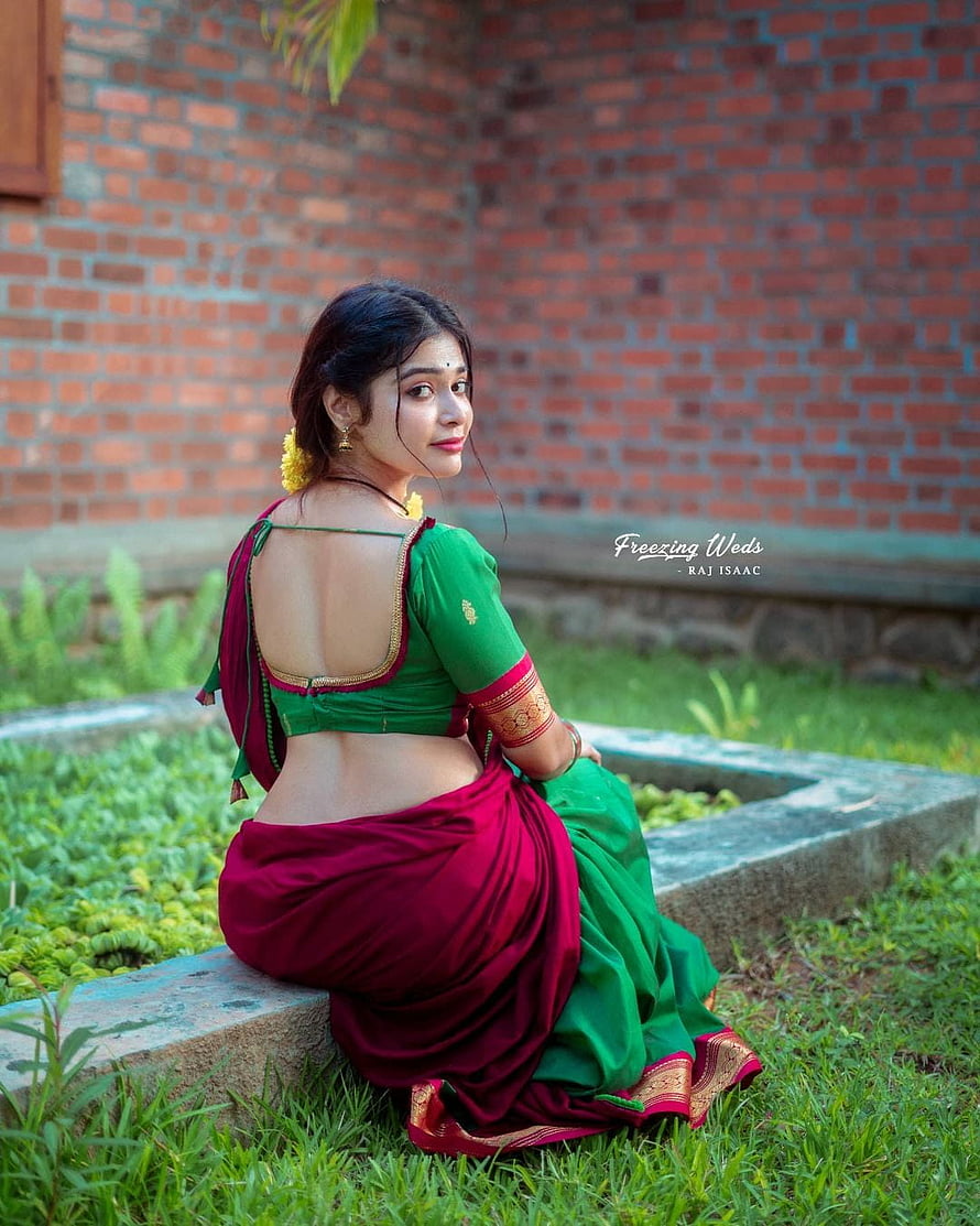 Dharsha Gupta in a Green and Maroon Saree Seated on a Garden Bench HD phone wallpaper