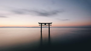Serene Torii Gate Silhouette in Calm Water at Sunset HD wallpaper