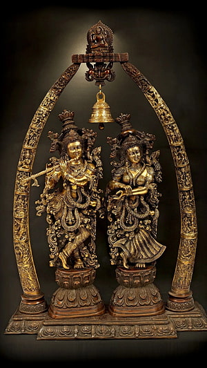 Ornate Bronze Radha Krishna Temple Arch with Hanging Bell and Intricate Carvings HD phone wallpaper