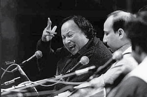 Nusrat Fateh Ali Khan performing passionately at a microphone with expressive hand gesture HD wallpaper