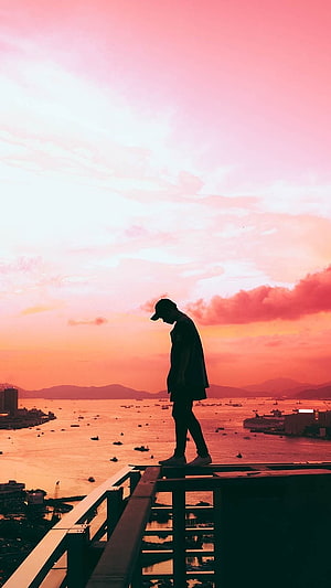 Silhouette of a man standing on a rooftop overlooking a harbor at sunset with pink and orange sky, Single Boy Attitude, Sad, Alone HD phone wallpaper