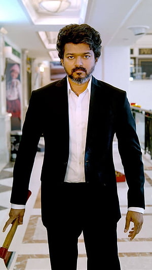 Vijay in a black suit holding an axe in a bright indoor corridor HD phone wallpaper