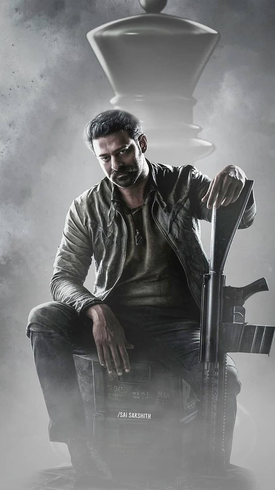 Prabhas as Raghavendra in gritty action pose with rifle and chess piece backdrop HD phone wallpaper