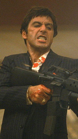 Al Pacino as Tony Montana in Scarface holding an assault rifle with a bloodied hand HD phone wallpaper