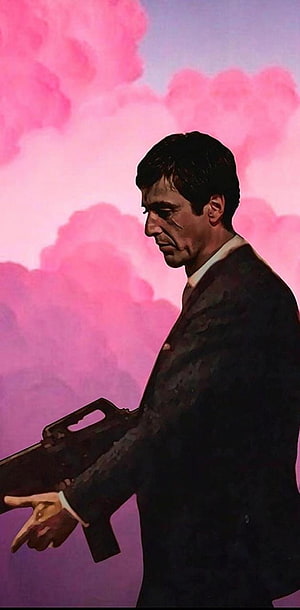 Tony Montana in a dark suit holding a submachine gun against a pink and purple cloudy sky HD phone wallpaper